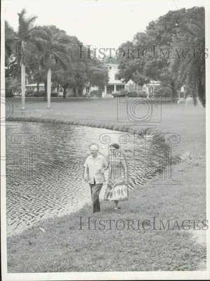 1957 Press Photo Retired couple walk along the edge of the lake - lrb00084