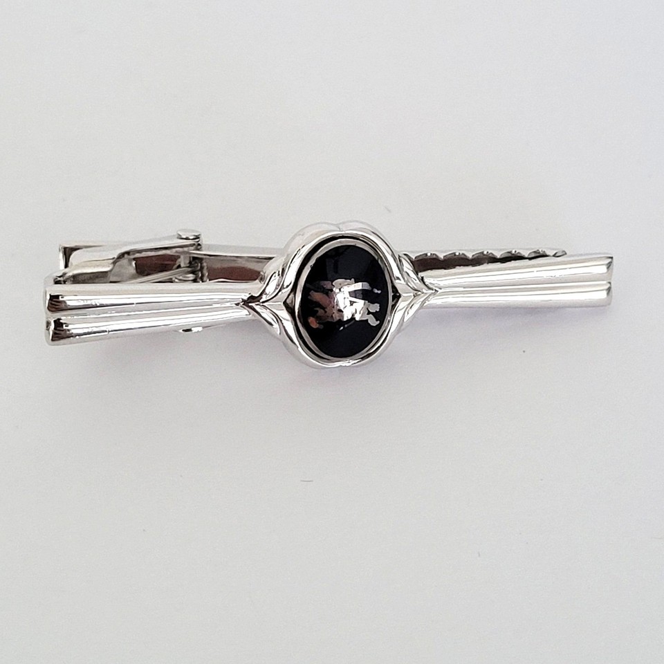 A vintage Burberrys (pre-rebrand) silver-tone tie clip bearing the iconic Prorsum equestrian knight — a rare branded collectible from when the logo still said something.