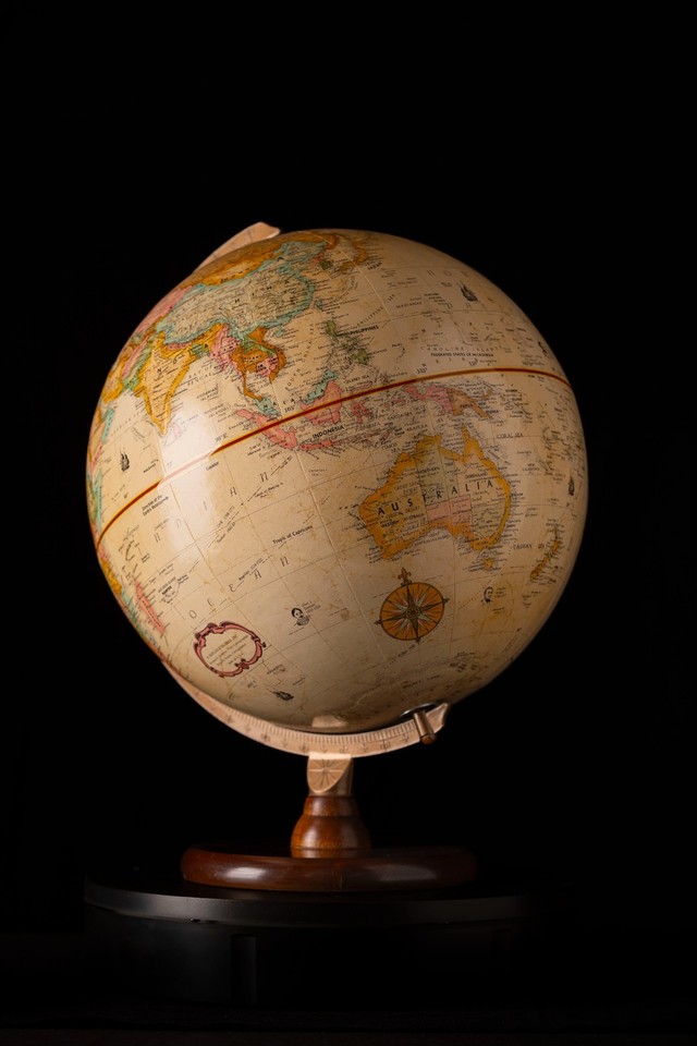 A MINT-condition Replogle 9" Classic Series globe on a wood base — pristine vintage American cartography ready to anchor any bookshelf or study.