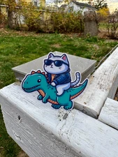 Cool Cat Riding Dinosaur Sticker - Fun and Adorable Vinyl Decal for Laptops, Wa