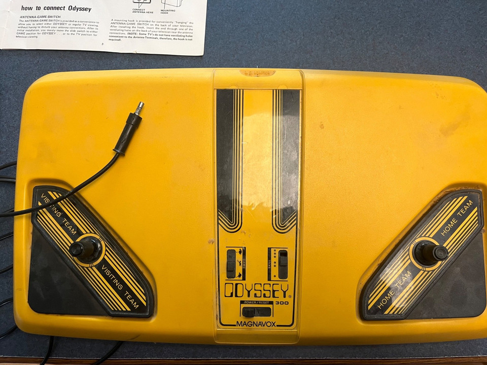 A 1976 Magnavox Odyssey 300 with manual — one of the earliest home video game consoles ever made, a genuinely historical artifact of gaming's origins.