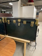 Vintage steamer trunk with a green finish and brass hardware
