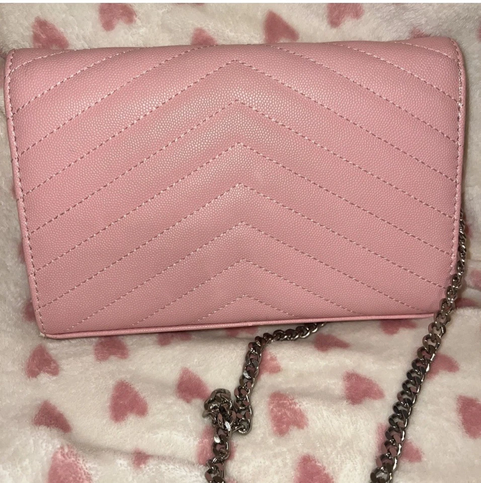 Bandolera de cuero sobre acolchado rosa con herrajes plateados.' Foto 2 de 4