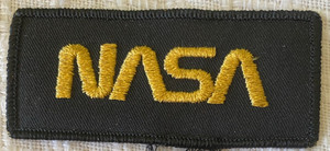 Nice Unused NASA Worm Logo Patch Black with Gold Letters 4" x 1.75"