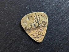 Brass guitar pick with cacti and a hammered sparkling texture - playable