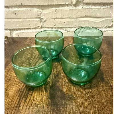 Set of four green glass roly poly style small bowls.