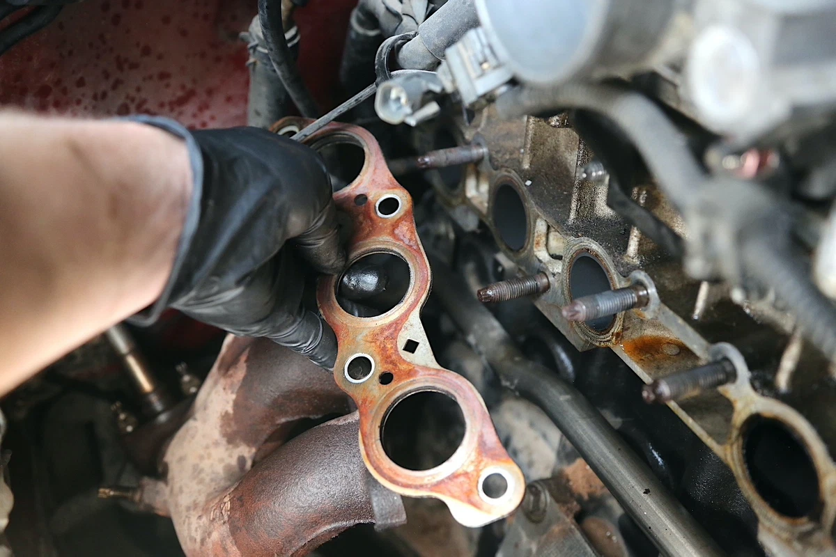 A mechanic holding an exhaust gasket.