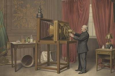 Victorian photographer preparing a large wooden camera in  portrait studio photo