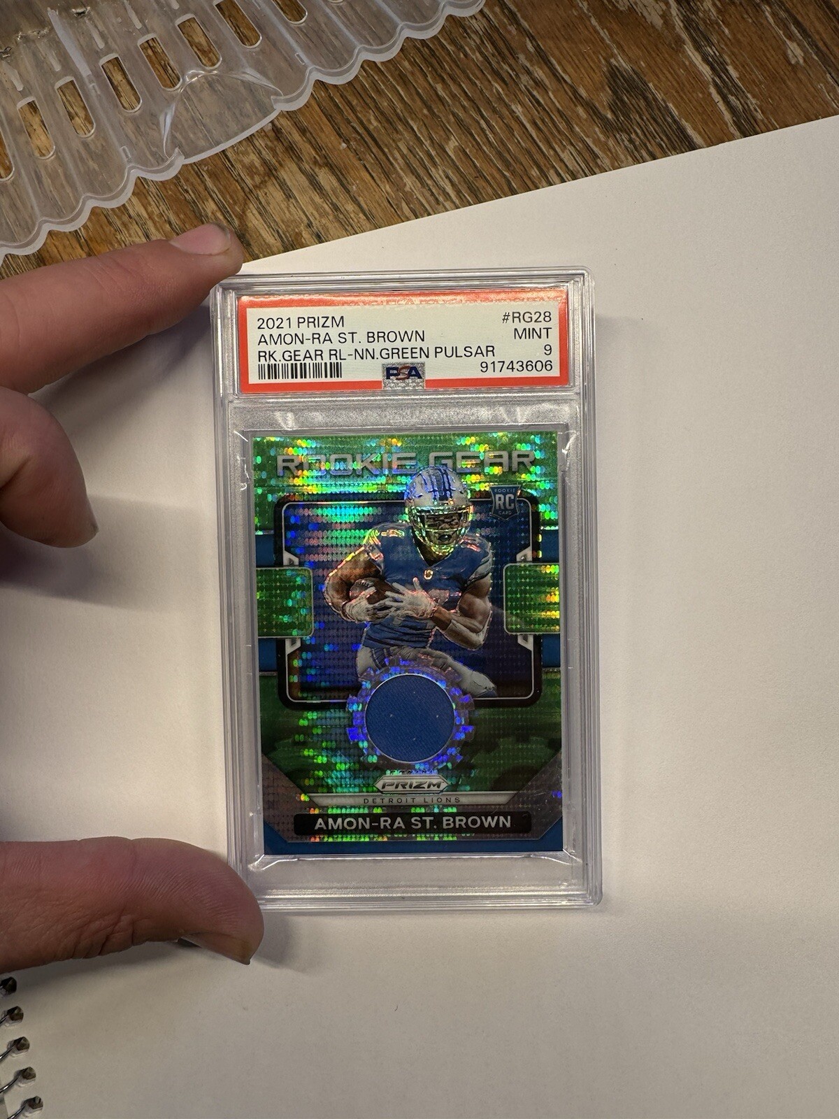 2021 Panini Prizm - Rookie Gear #RG-28 Amon-Ra St. Brown green pulsar PSA 9