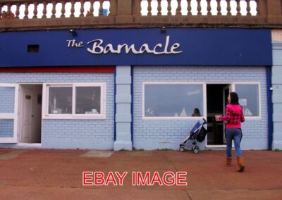PHOTO  THE BARNACLE ON THE SEAFRONT AT WHITLEY BAY. AN ISOLATED CAFE AMONG A NUM