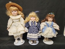 Lot of 3 porcelain dolls with stands Blonde blue eyed brunette with brown eyes