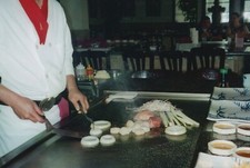 Chef Preparing Teppanyaki Japanese Cuisine At Hibachi Grill