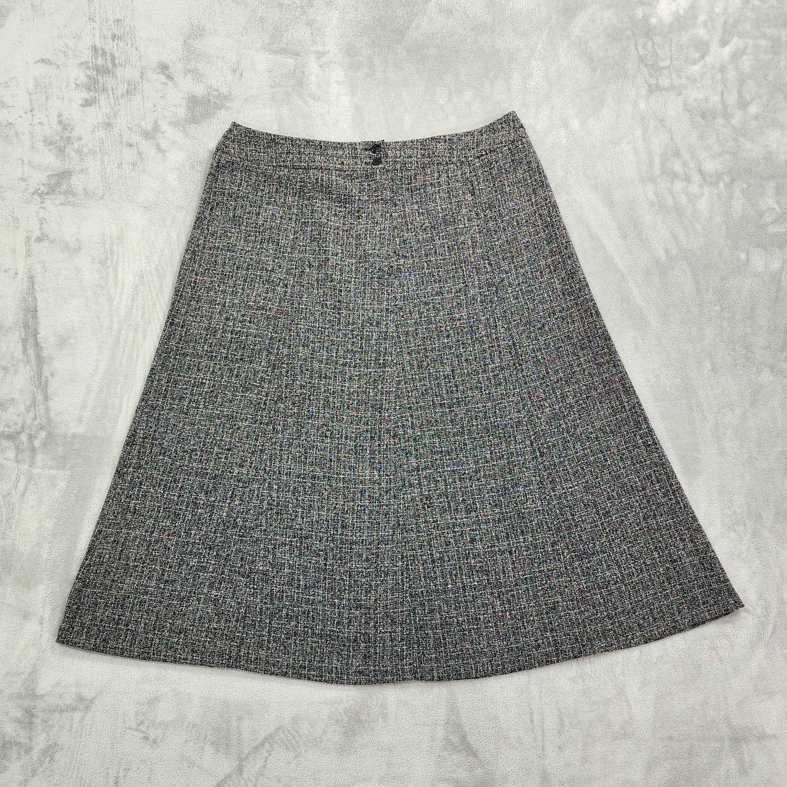 Grey tweed A-line midi skirt laid flat on a neutral background.