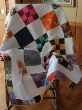 Beautifully hand crafted nine-patch  quilt that is cheerful scrappy style