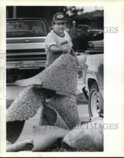 1990 Press Photo Marco Hernandez removes flood damage carpet at home in Harvey
