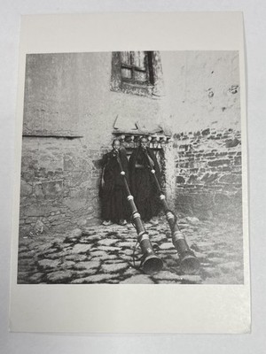 Postcard two priests in shigatze, tibet, blowing twelve-foot trumpets