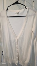 white V-neck cardigan from the brand Forever 21. The tag with "Forever" is...