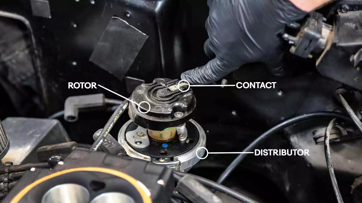 A mechanic points out the distributor cap.