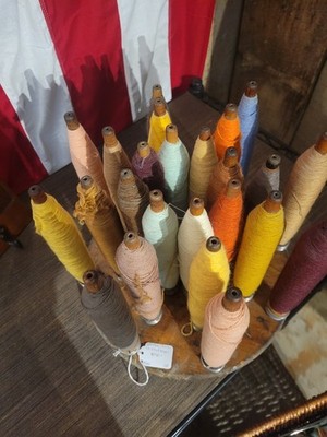 Assorted Colored Weaving Bobbins with Thread on Wooden Holder