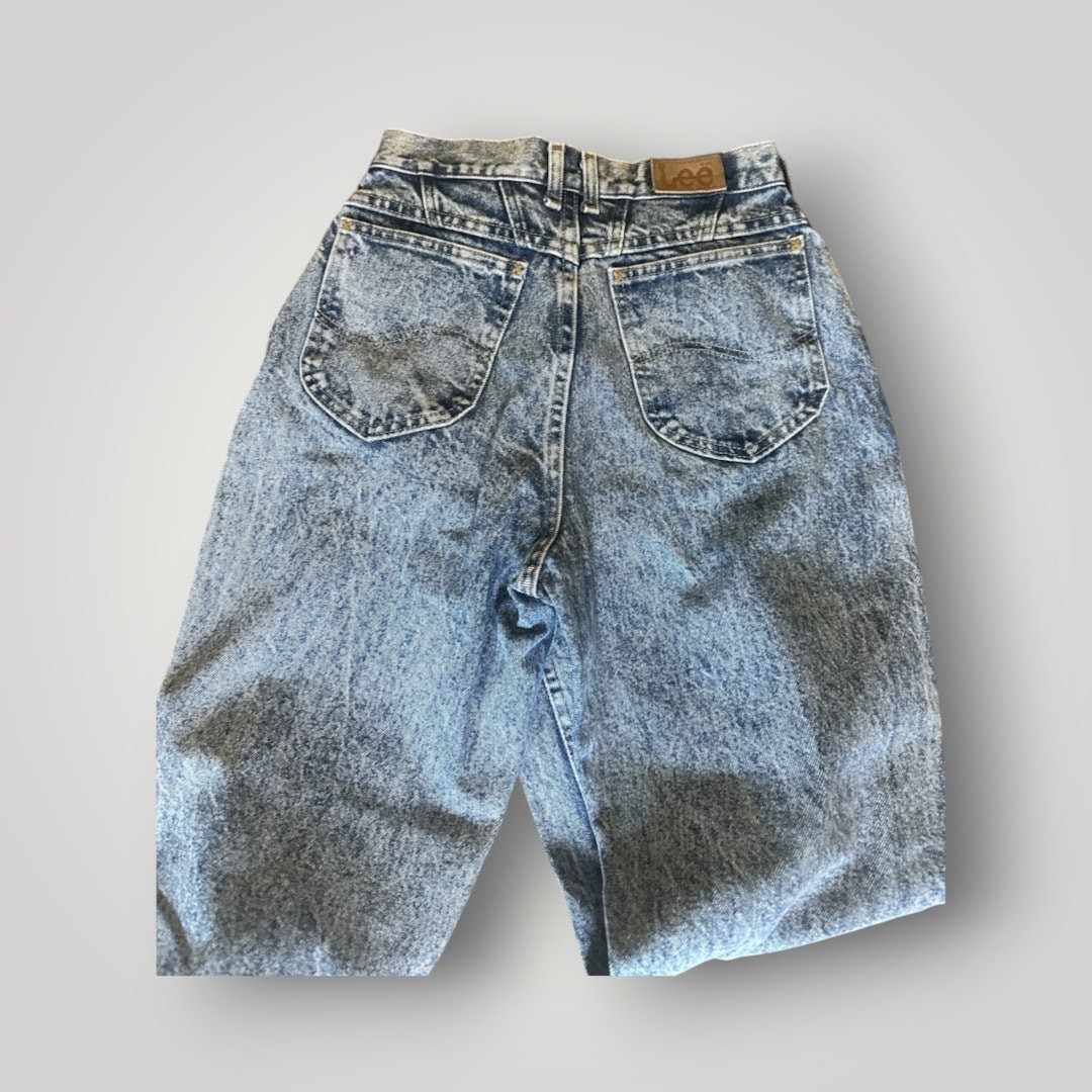 Light blue high-rise vintage Lee mom jeans with back pocket and brown leather Lee badge on waistband, made in USA.