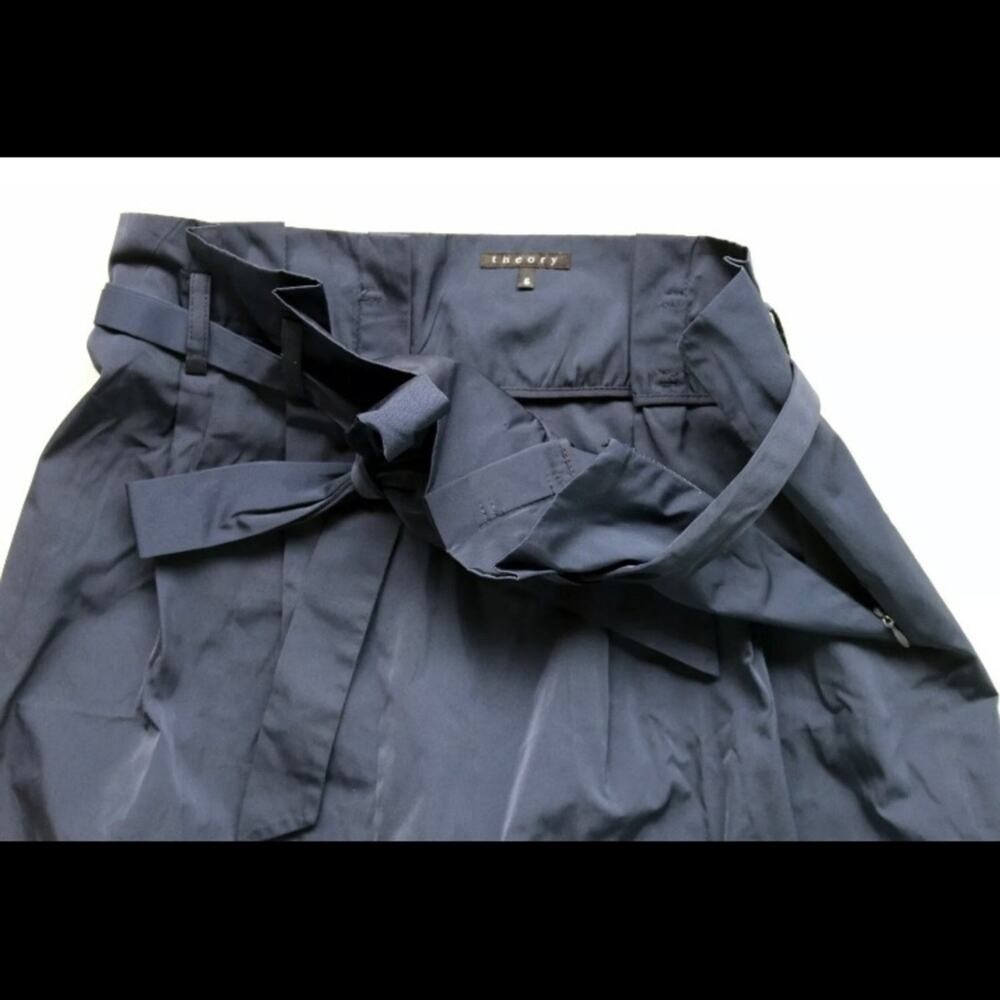 Navy blue paperbag waist skirt with matching fabric belt, side buckle detail, and “THEORY” label on waistband.