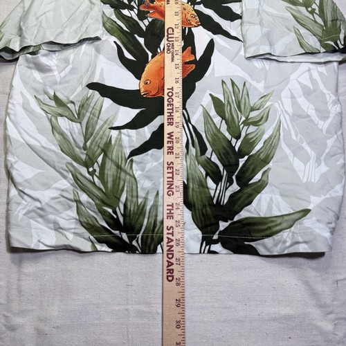 Vintage white Wyland AFTCO Bluewater men’s Hawaiian shirt with orange fish rayon and green leaf pattern, shown beside a wooden ruler.