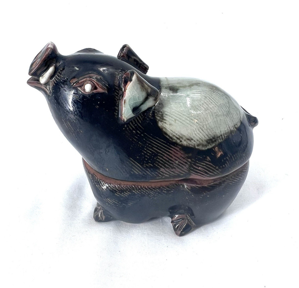 A vintage ceramic pig that moonlights as both a candle holder and a trinket box — the kind of quirky dual-purpose collectible that looks like it escaped from a grandmother's curio cabinet in the best possible way.