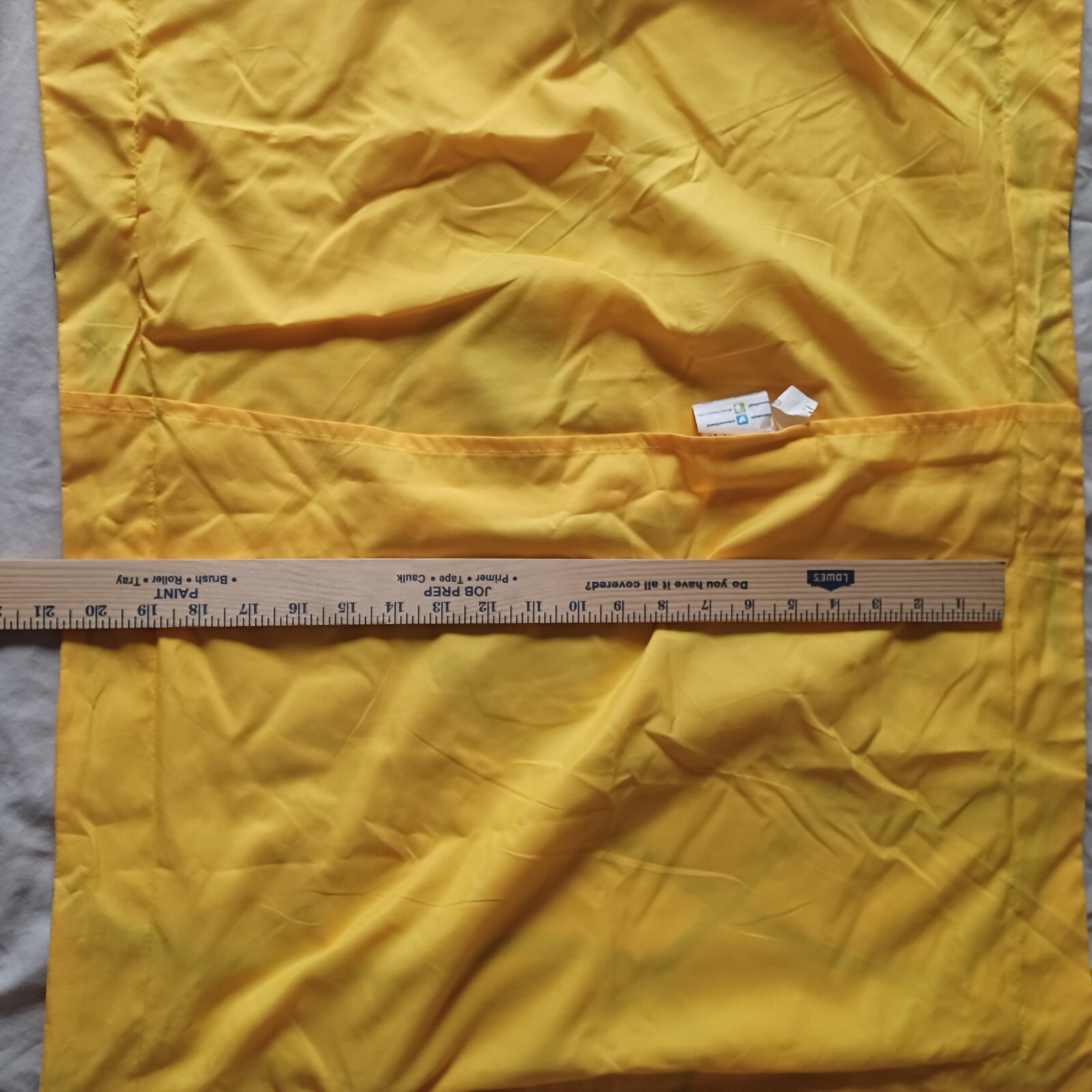 Yellow fabric Golden State Warriors NBA pillow case with 19 x 25 dimensions, shown with a wooden ruler for scale.