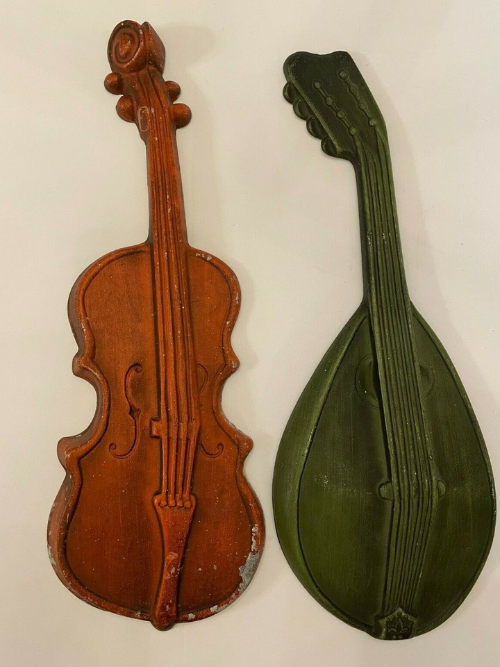 Ornate cast metal instrument wall plaques from the Royal brand — a staple of mid-century parlor decor that's genuinely hard to find in pairs.