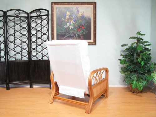 White rattan recliner chair with padded backrest and armrests, placed on a light wood floor near a wall painting.