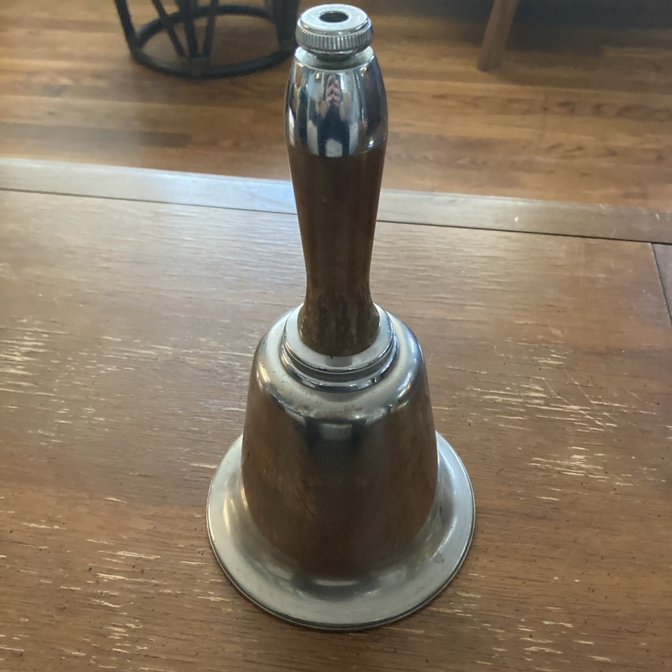 An Art Deco cocktail shaker shaped like a ringing bell — silver metal with wood accents, genuinely hard-to-find and visually stunning.