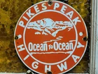 VINTAGE PIKES PEAK PORCELAIN SIGN OLD COLORADO OCEAN HIGHWAY ROCKY MOUNTAINS 12"