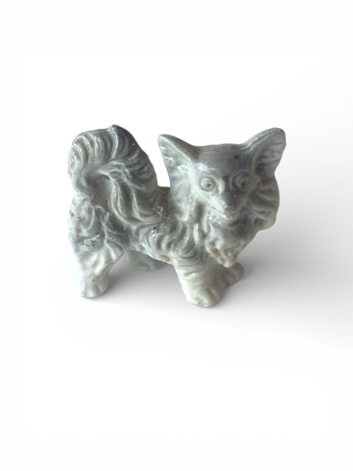 A teeny MCM Japan porcelain Pomeranian figurine — the kind of kitsch-perfect vintage find that looks intentional on any shelf.