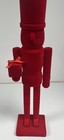 Red Christmas toy soldier with gift in hand ￼ — photo 1