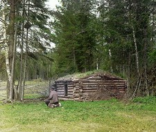 Foto: 1912 cabaña de troncos en el bosque hombre sentado cerca de la cabaña escena del bosque