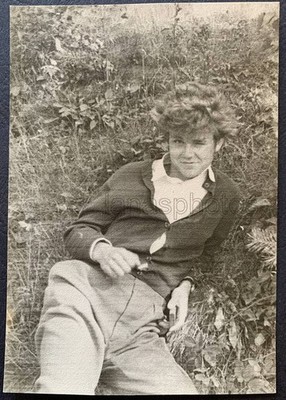 Guy lying on grass Handsome young man boy teen Interesting face Nice hair photo