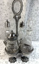 Vintage Cruet Set, 4 bo9ttles and Silver Plated Holder with Ornate Feet