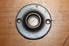 Round antique cast iron doorknob escutcheons with smooth metal finish and two screw holes on a wooden surface.