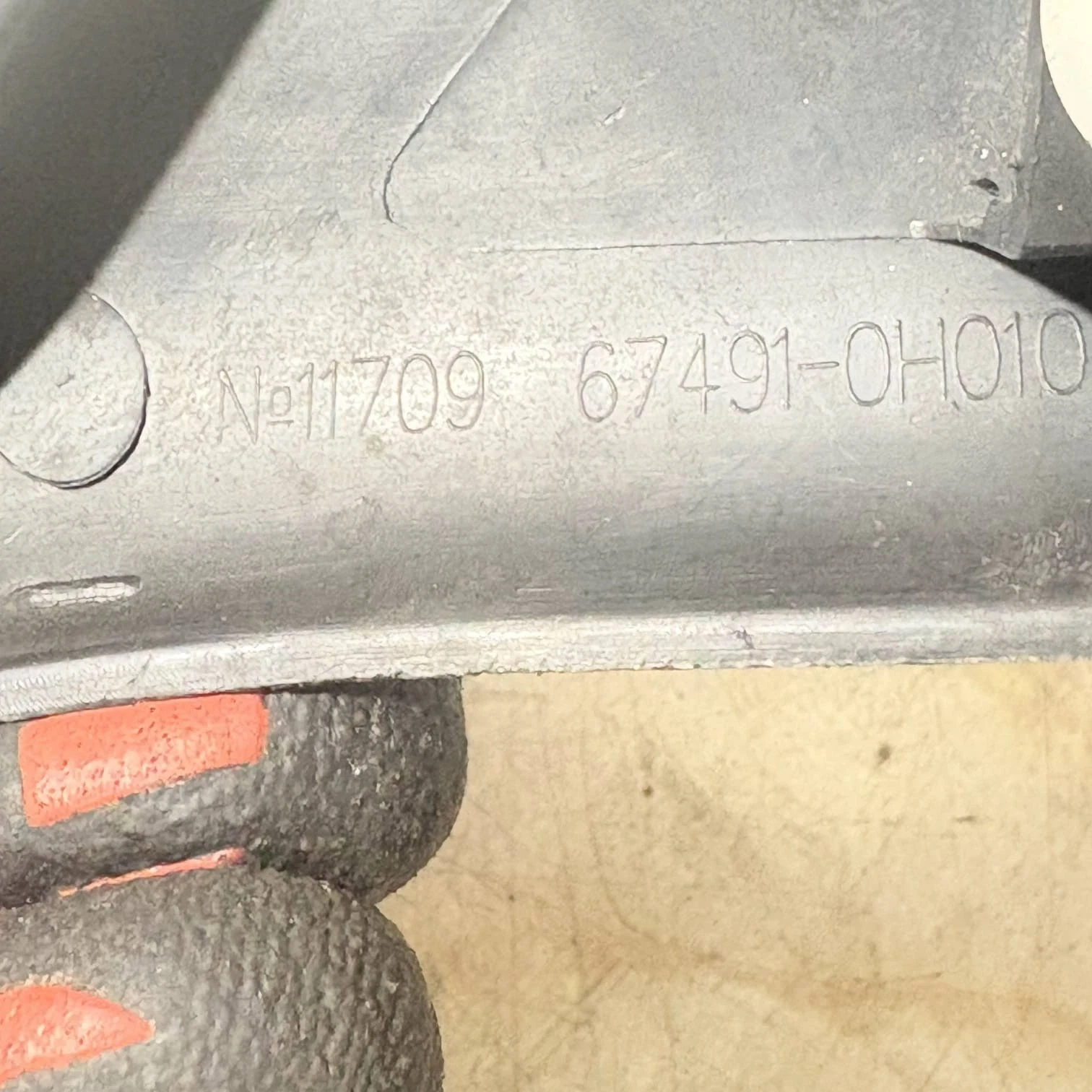 67491-0H010 stamped part number close up