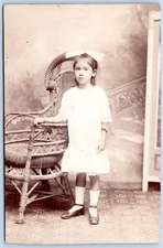 Postcard RPPC Young Girl Big Hair Bow Wicker Chair Studio Photo SOLIO R66
