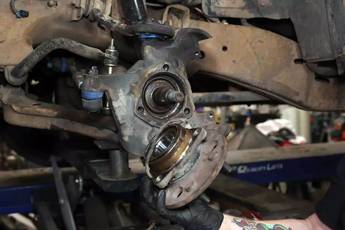 A mechanic removes the wheel hub.
