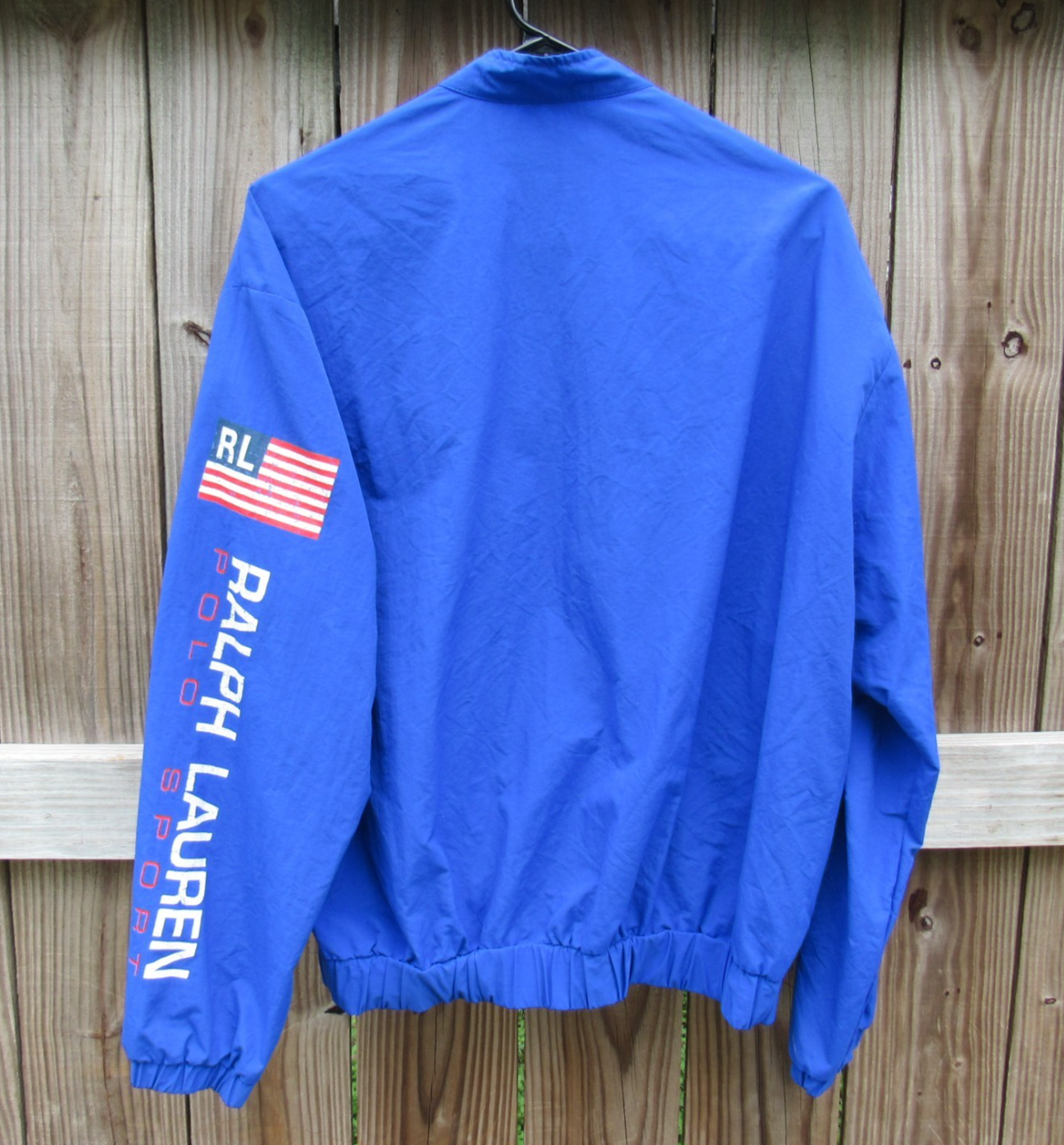 Royal blue Vtg 90s Polo Sport Ralph Lauren jacket with black strap, red, white, and blue chest stripes, and visible RL logo.