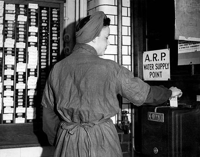 Worker clocking in for her shift at an arms factory in England dur- Old Photo
