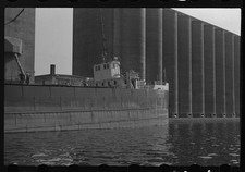 Photo:1930s Cargo Ship at Grain Silos Waterfront Industrial Scene