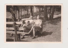 Family on Bench in Forest Park Facing the Direction of the Sun's Rays Snapshot