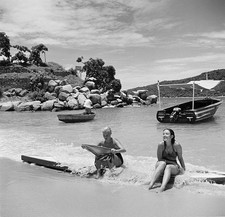 Two women sit in the surf on paddle boards in Acapulco Mexico 1952 Old Photo