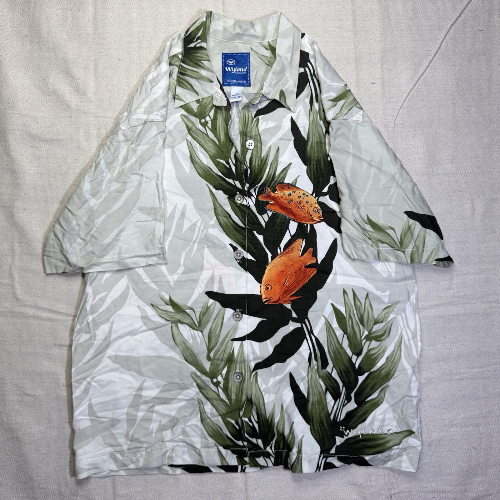Light gray vintage Wyland AFTCO Bluewater men’s Hawaiian shirt with orange fish and green leaf print.