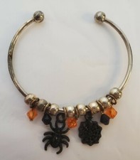 Silver-colored Halloween bracelet with beads, spider, and web.