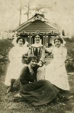 YOUNG WOMEN POSED IN FRONT OF CUTE TINY COTTAGE. SILVER PRINT.