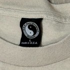 Tan collar Y2K VTG T&C surf shirt with black circular logo, “Made in U.S.A.” text, and wave design on front.